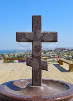 Orthodox cross made of granite near the chapel.