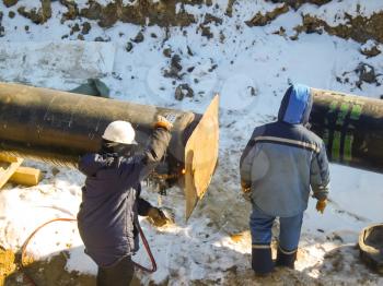 The workers engaged in the construction of the pipeline. Welders build the pipeline. Installation work in the construction and installation of the pipeline.