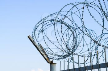 Barbed wire on the fence. Protective fencing specially protected object of barbed wire. Stamped barbed wire.