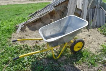 Gardening wheelbarrow for transportation of sand and earth. Two-wheel yellow car.