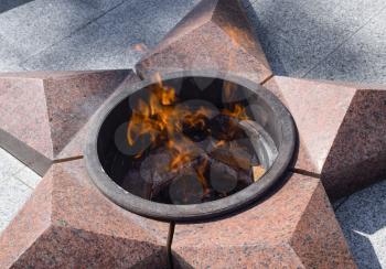 Burning of eternal fire. Five-pointed star made of granite memorial to the memory of killed soldiers.