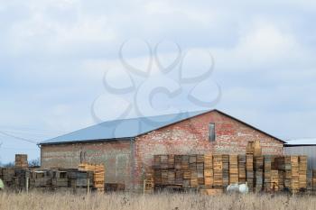 Large barn. Industrial warehouse building. Boxes of wood against the wall.