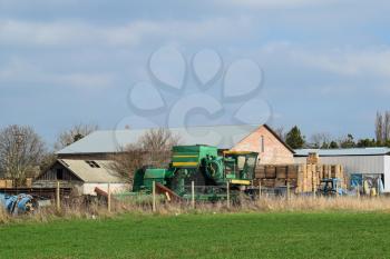 Old tractor and harvester in a brick shed. Store the old equipment.