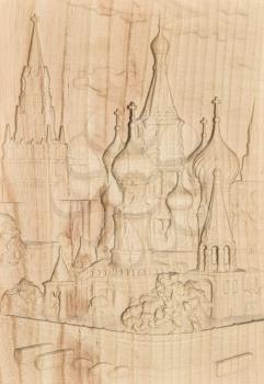 Woodcarving. Carved relief image of the Moscow Kremlin on a wooden plank.