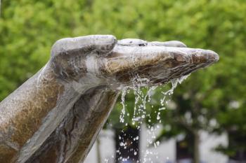 Hands statue from which water flows. Monument decoration on the fountain.