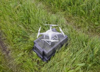Quadrocopters on a plastic box in the grass. Preparation quadrocopter to fly.