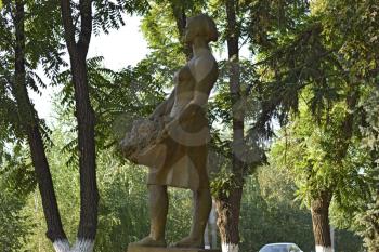 Statue of women collecting grapes. Statue of brown in the shade of acacia trees.