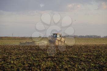Tractor plowing plow the field. Tilling the soil in the fall after harvest. The end of the season.