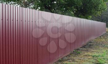 Diagonal pattern of metal profile. Fences from the galvanized iron painted by a polymeric covering.