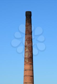 brick factory chimney. Tube for propulsion bricks in the furnace. Pipe on a background of blue sky.