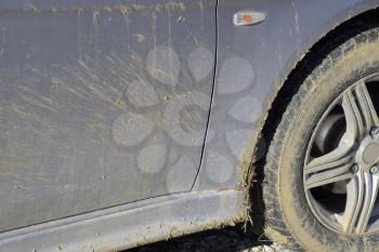 The mud on the wheels, fenders and car doors. The result is a trip through the mud. Dirty car.