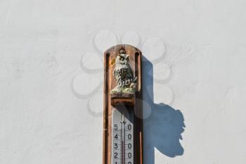 Wall thermometer. A device for measuring the ambient air temperature. Ornament of the owl, decoration appliance thermometer.