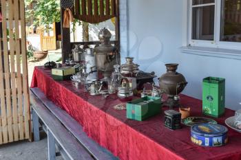 Poltavskaya village, Russia - July 28, 2015: Russian somovar. The device for making tea in the autonomous conditions. Table with vintage cutlery and crockery.