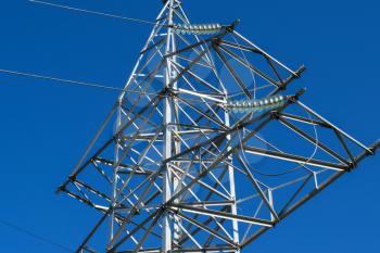 Supports high-voltage power lines against the blue sky.