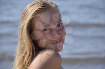 The girl blonde on a background of sea water. Beautiful young woman.