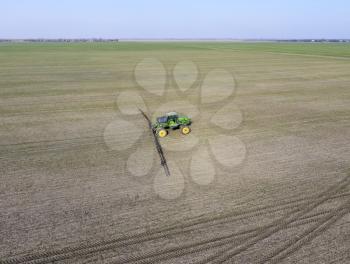 Tractor with hinged system of spraying pesticides. Fertilizing with a tractor, in the form of an aerosol, on the field of winter wheat