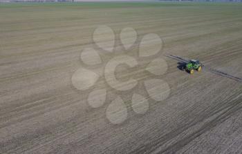 Tractor with hinged system of spraying pesticides. Fertilizing with a tractor, in the form of an aerosol, on the field of winter wheat