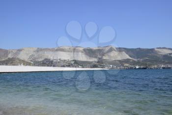 international seaports. Cargo port with port cranes. Sea bay and mountainous coast.