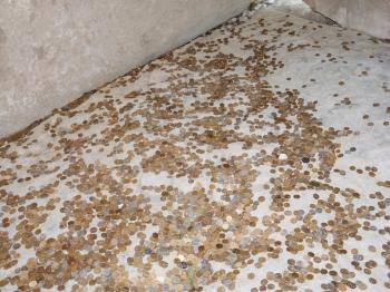 Coins on a concrete floor. Throwing for luck and success of coins in the holy site.