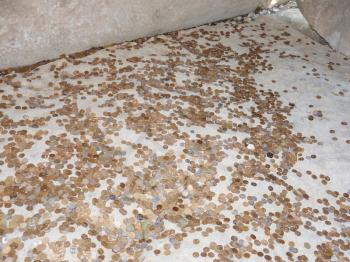 Coins on a concrete floor. Throwing for luck and success of coins in the holy site.