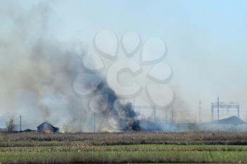 Fire on irrigation canals. Burning dry grass and cane fields in irrigation system. Burning debris and rubber.