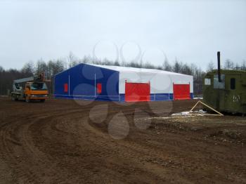 Hinged temporary garage for special equipment. rubberized tarpaulin.