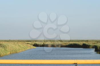 The gas pipeline through the small river. Equipment of oil and gas crafts.