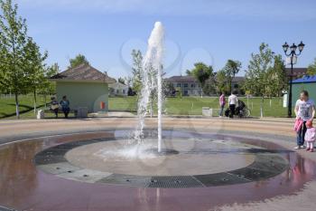 Russia, Poltavskaya village - May 3, 2016: Splashes of a fountain in the park. Beautiful water jet emitted fountain.
