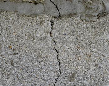 A crack in the concrete wall. The destruction of the wall from the gray blocks.