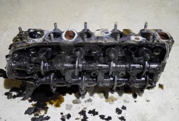 The head of the block of cylinders. The head of the block of cylinders removed from the engine for repair. Parts in engine oil. Car engine repair in the service.