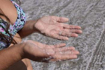 Salt on the girl's hands. Dried salt on the hands of women of the ancient lake.