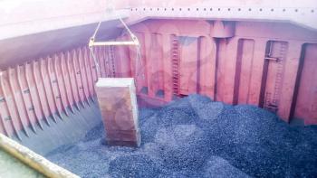 The cargo compartment of the ship, filled with coal. Loading of anthracite. Transportation of coal