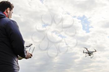 A man with a quadrocopter in his hands. White kvadrokopter prepare for flight.