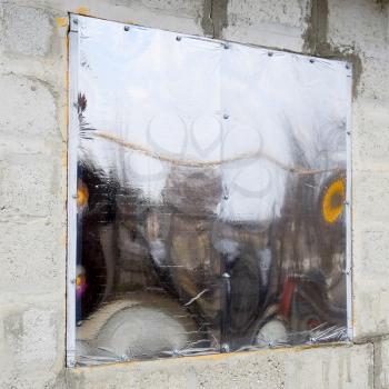 A window made of plexiglas in a concrete wall. A window with a reflective sticker