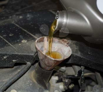 Oil change in the engine of the car. Filling the oil through the funnel. Car maintenance station