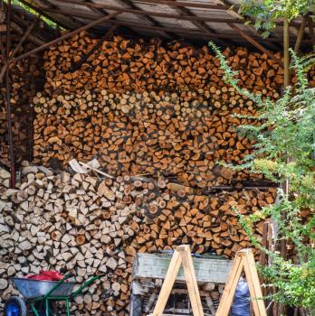 Firewood Logs in a woodpile under the roof. A pile of firewood