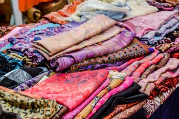 Indian fabrics folded on the counter. Trade in fabrics from india. Fabric with patterns and patterns.