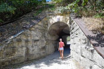 The girl enters the tunnel. Tunnel under the railway.