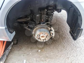 Hub with brake disc and brake shoes. The arch of the car with the removed wheel