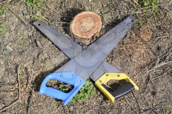 Two saws hacksaws lie across. Garden tool saw. Two saws hacksaws lie across