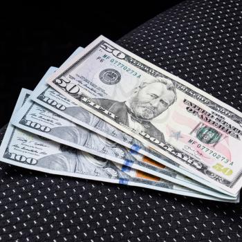Several banknotes American dollars lie on the car seat. The money in the car.
