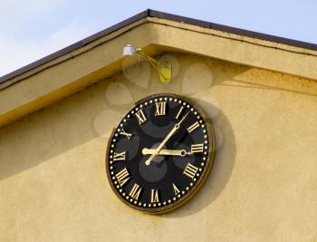 Clock with roman numerals on the front of the house. Watch face