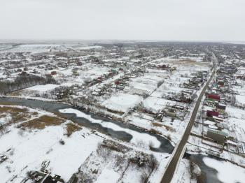 Winter view from the bird's eye view of the village. The streets are covered with snow.