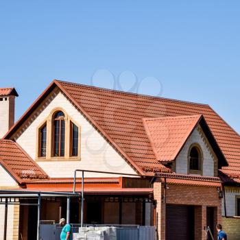 Detached house with a roof made of steel sheets. Roof metal sheets. Modern types of roofing materials.