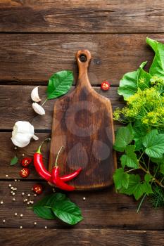dark wooden culinary background with different herbs and spices, top view, rustic style