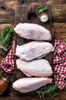 Raw turkey wings on wooden background top view, flat lay