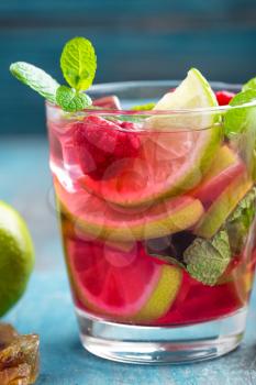 Refreshing mint cocktail mojito with rum, lime and raspberry, cold drink or beverage