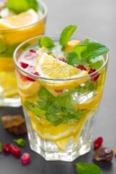 Lemon mojito cocktail with fresh mint and pomegranate, cold refreshing summer drink or beverage with ice