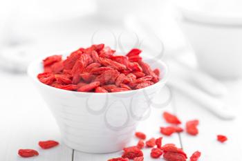 Goji berries in bowl on white background