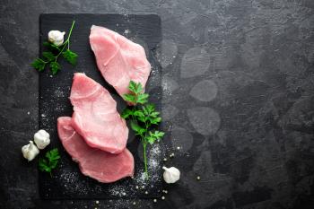 Raw meat, beef steak on black background, top view